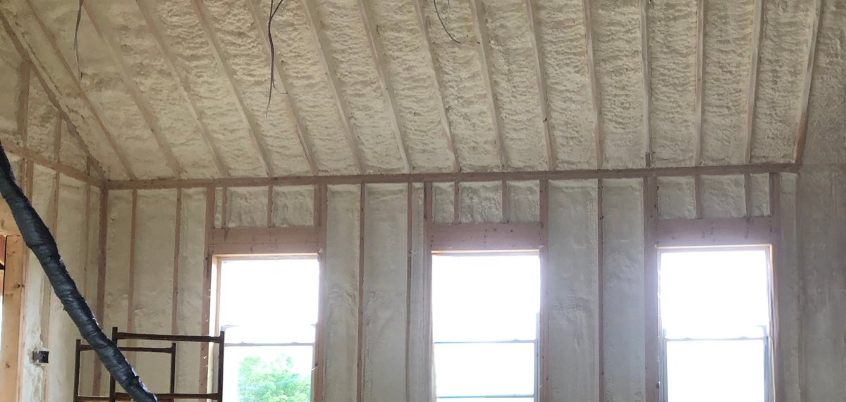Vaulted cathedral ceiling and walls sprayed with foam insulation in a Maine home under construction