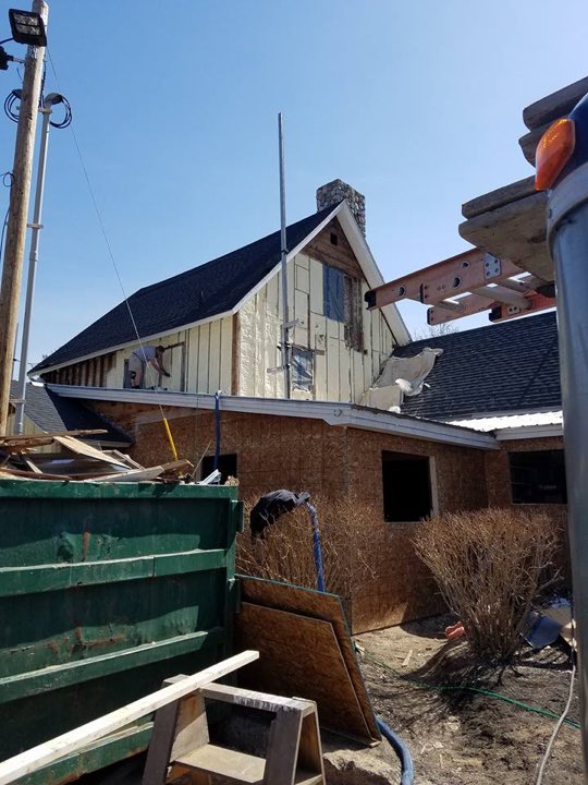 Exterior insulation retrofit in progress with the original siding stripped back to the sheathing